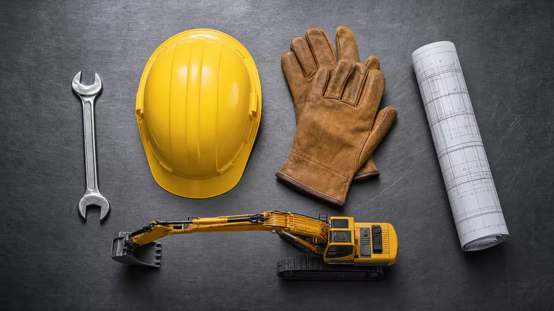 Overhead flat lay of construction equipment essentials on a brushed steel plate: unbranded chrome wr