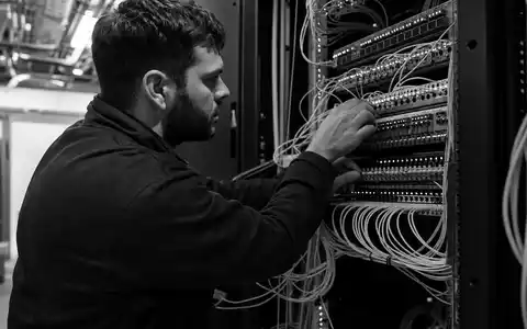 Dokumentarische Schwarzweiß-Aufnahme eines Netzwerktechnikers repräsentiert Cisco Systems Inc., ISIN US17275R1023, im IT-Infrastruktursektor - Foto: THN