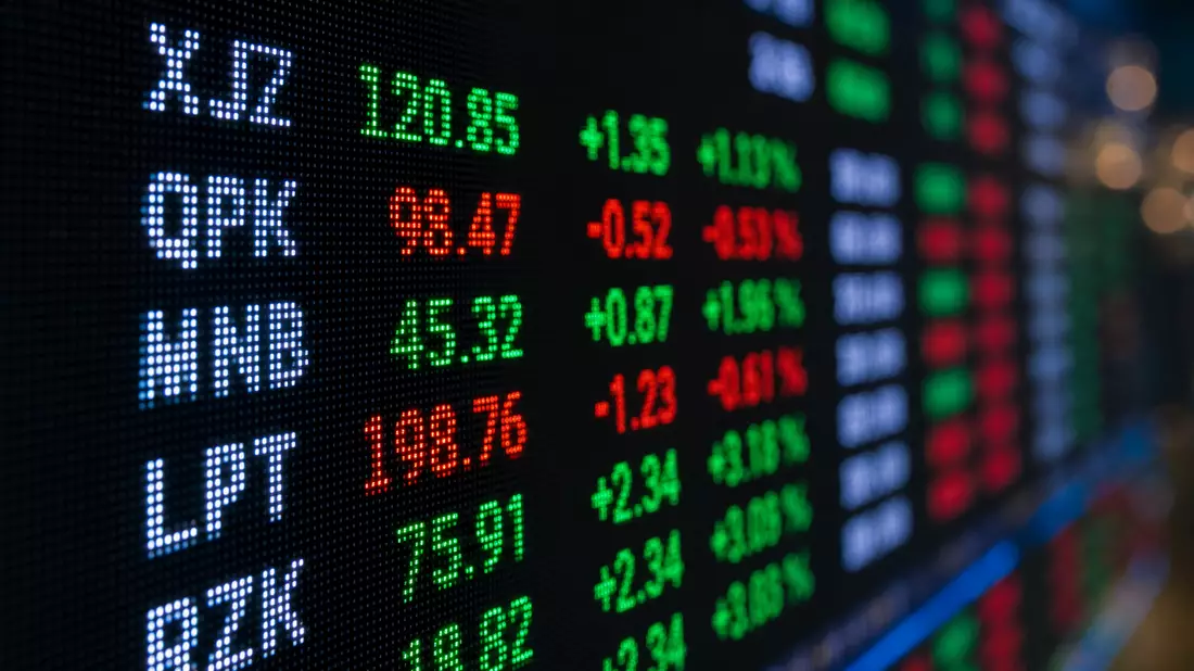 Extreme macro close-up of a financial stock ticker LED display screen showing fictional ticker symbo