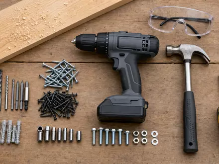 Home Depot US4370761029 präsentiert Flatlay-Arrangement von Akkubohrer, Hammer, Maßband, Schrauben und Schutzbrille - Foto: THN
