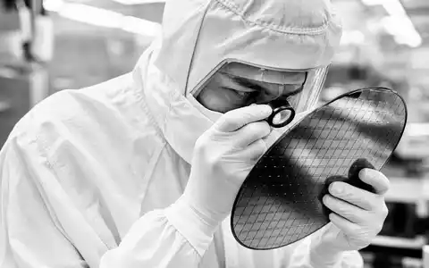 Intel Corporation US4581401001: Ingenieur im Reinraum prüft dokumentarisch einen Silizium-Wafer mit Lupe - Foto: THN