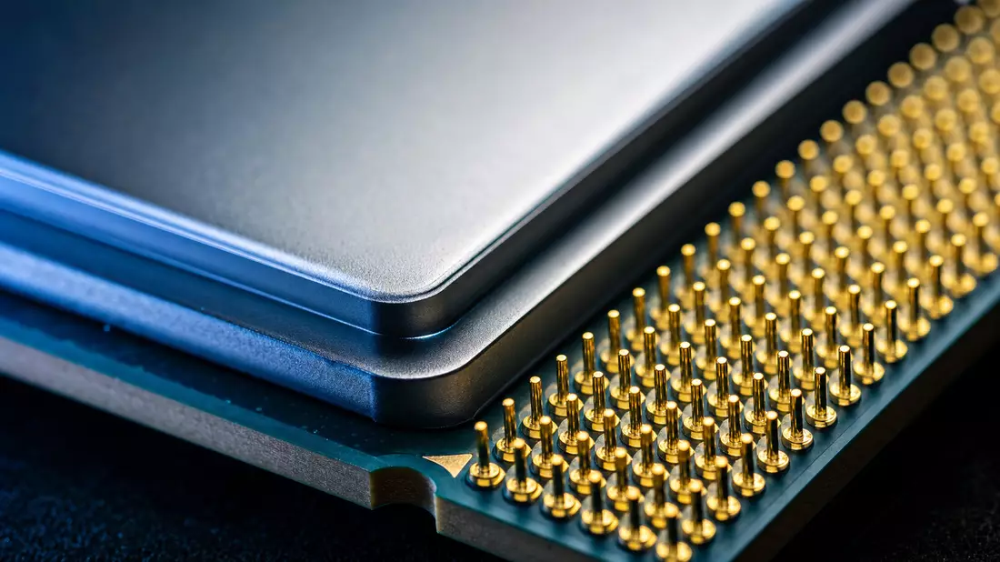 Extreme macro photograph of a CPU processor chip corner revealing the polished metallic heat spreader surface and dense rows of gold contact pins in a pin grid array, dramatic blue studio lighting
