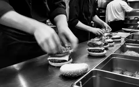 McDonald's Küchenpersonal US5801351017 belegt Burger in der offenen Küche, eine dokumentarische Schwarz-Weiß-Reportage - Foto: THN