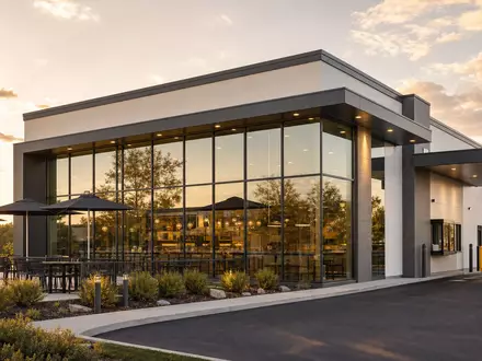 McDonald's Restaurantgebäude US5801351017 besticht mit moderner Glasfront, einer Drive-Thru-Spur und gepflegter Außenterrasse - Foto: THN