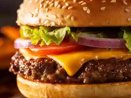 McDonald's Burger-Nahaufnahme US5801351017 zeigt schmelzenden Käse, frischen Salat und Sesam im Licht - Foto: THN