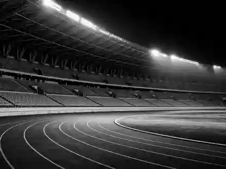 Nike Inc US6541061031 zeigt ein leeres Sportstadion in dramatischer Schwarz Weiß Reportage Fotografie nachts - Foto: THN