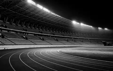 Nike Inc US6541061031 zeigt ein leeres Sportstadion in dramatischer Schwarz Weiß Reportage Fotografie nachts - Foto: THN