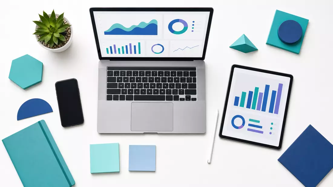 Aufgeräumtes Overhead-Flatlay mit Laptop, Tablet und türkis-blauen Büro-Designobjekten auf Weiß