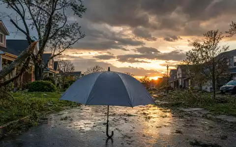 Travelers US89417E1091 zeigt fotorealistischen Schutzschirm nach schwerem Sturm im Wohnviertel mit Trümmern - Foto: THN