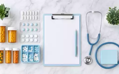 UnitedHealth Group US91324P1021 symbolisiert durch Pharmacy-Flatlay mit Medikamenten Stethoskop Blisterpack und Klemmbrett - Foto: THN