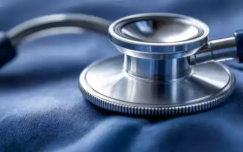 UnitedHealth Group US91324P1021 visualisiert durch extreme Makroaufnahme eines Stethoskops auf blauem Stoff - Foto: THN