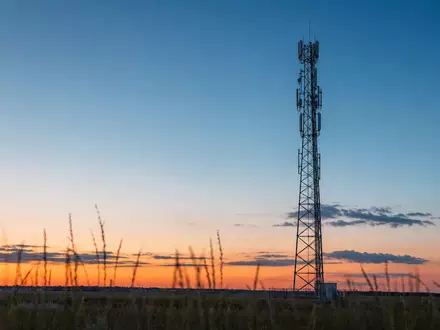 Verizon US92343V1044 zeigt einen generischen 5G-Antennenmast bei goldenem Sonnenuntergang auf weitem offenem Feld - Foto: THN