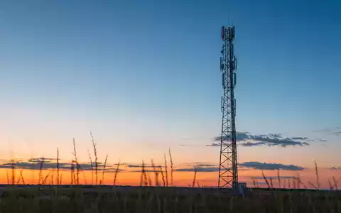 Verizon US92343V1044 zeigt einen generischen 5G-Antennenmast bei goldenem Sonnenuntergang auf weitem offenem Feld - Foto: THN