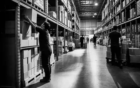 Walmart US9311421039 in einer Schwarz Weiß Reportage von Arbeitern beim Bestücken der Lagerregale - Foto: THN