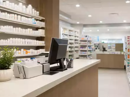 Walgreens US9314271019 zeigt fotorealistisches Apothekeninterieur mit hell erleuchteten Regalen und modernem Rezeptpult - Foto: THN