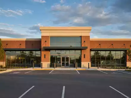 Walgreens US9314271019 zeigt modernes Apotheken-Gebäude aus rotem Ziegel und Glas im amerikanischen Vorstadtbereich bei Goldstundenlicht - Foto: THN
