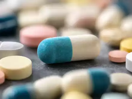 Walgreens US9314271019 zeigt extreme Makro-Nahaufnahme farbiger pharmazeutischer Tabletten und Kapseln auf grauem Untergrund - Foto: THN