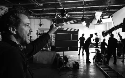 Disney US9314271084 dokumentiert Filmproduktion mit Regisseur und leerer Filmklappe sowie Filmcrew im Hintergrund - Foto: THN