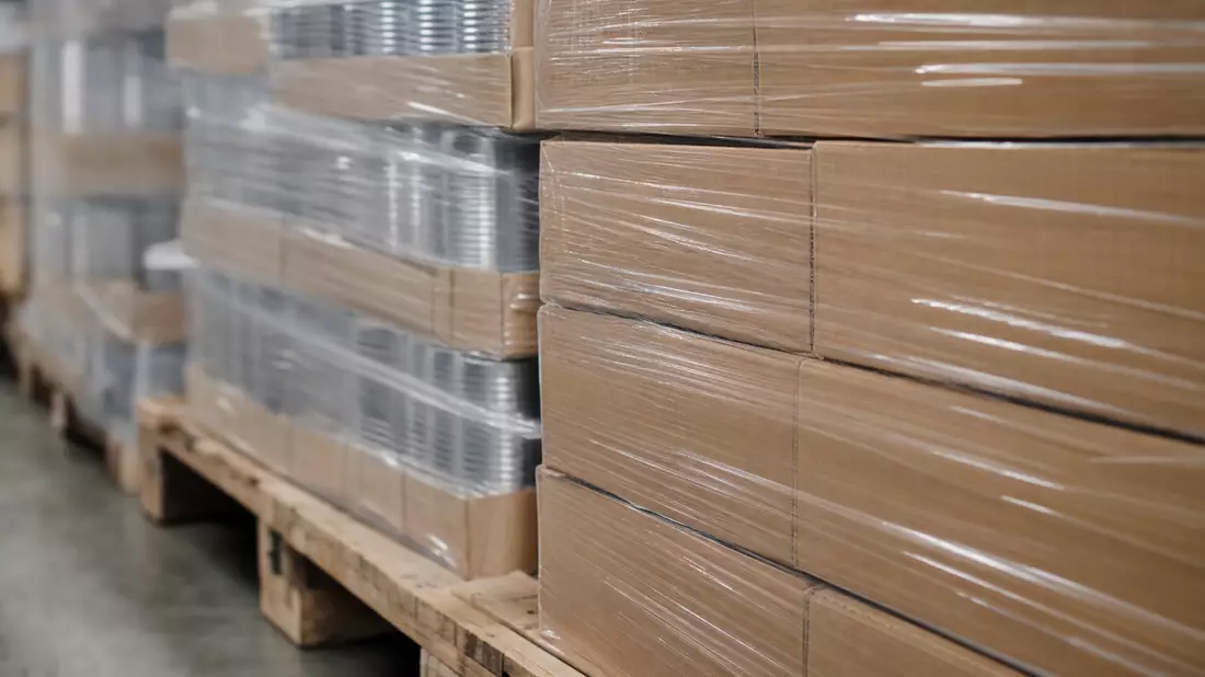 Makrofoto von folienverpackten Kartons und Waren auf einer Holzpalette