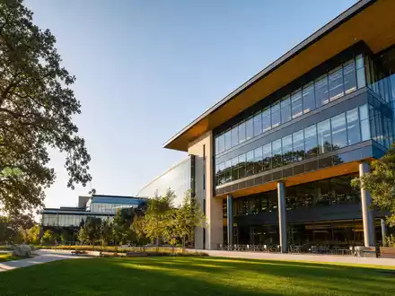 Netflix US64110L1061 zeigt einen modernen Silicon-Valley-Tech-Campus mit Glasfassade und Eichen in Kalifornien - Foto: THN