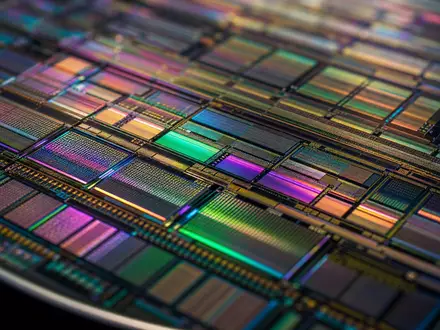 Applied Materials Inc. (US0382221051) fokussiert Makroaufnahme eines Silizium-Wafers mit schimmernden Mikrochip-Schaltkreismustern in Nahaufnahme - Foto: THN