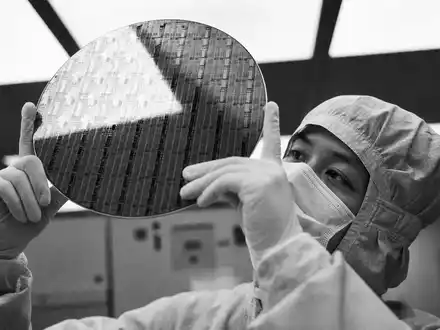 Micron Technology US5951121038 Techniker hält NAND Flash Wafer im Reinraum als Schwarz Weiß Reportage - Foto: THN