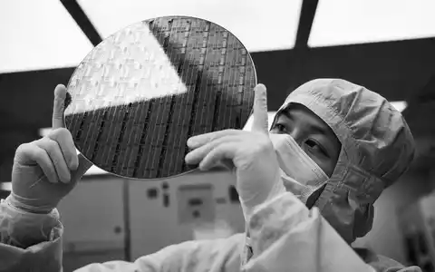 Micron Technology US5951121038 Techniker hält NAND Flash Wafer im Reinraum als Schwarz Weiß Reportage - Foto: THN