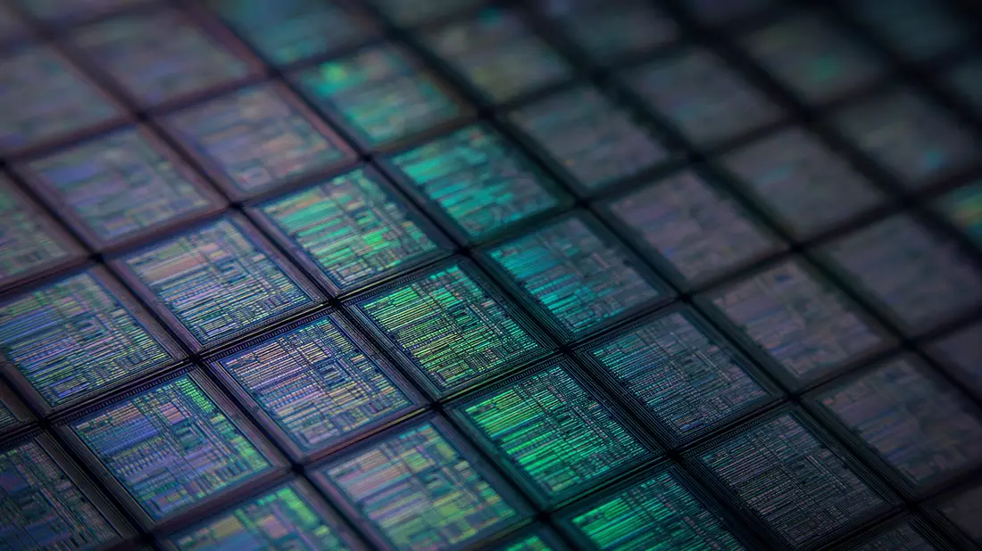 Extremes Makrofoto einer Siliziumwafer-Oberfläche mit Hunderten identischer Die-Zellen im Gitternetz