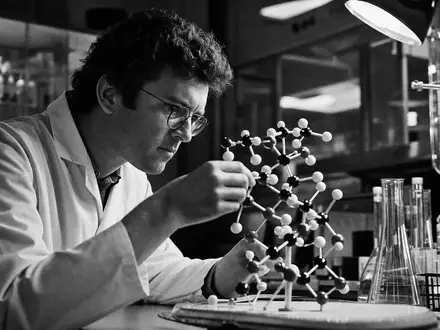 AstraZeneca US6549022043 Schwarz Weiß Reportage eines Forschers mit Molekülmodell im Pharmalabor dramatisch beleuchtet - Foto: THN