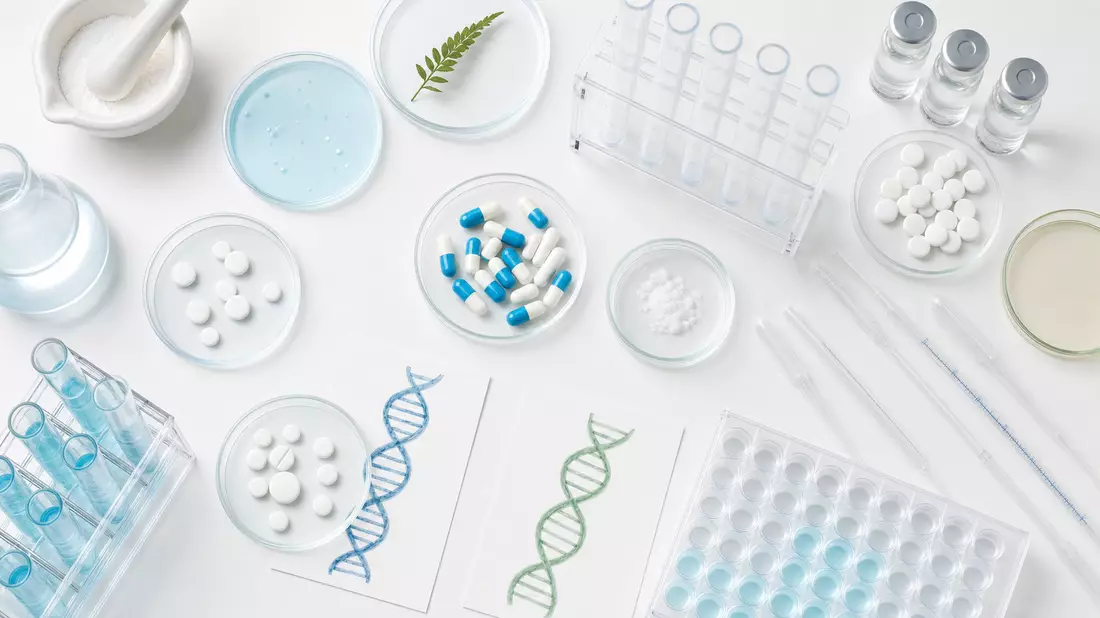 Flachbild-Draufsicht pharmazeutischer Laborartikel auf weißem Untergrund mit ungebrandeten Tabletten, Kapseln, Petrischalen, Pipetten und DNA-Illustrationen