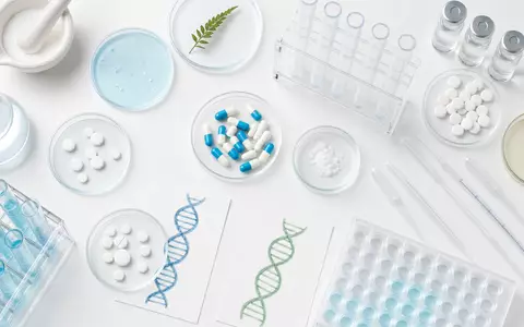 AstraZeneca US6549022043 Flatlay mit pharmazeutischen Laborartikeln generischen Tabletten Petrischalen und DNA Modellen - Foto: THN