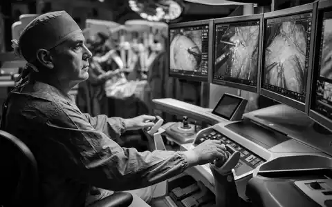 Intuitive Surgical US46120E6023 Schwarz-Weiß-Reportage zeigt Chirurgen an der Steuerkonsole mit operativem Monitor-Array - Foto: THN