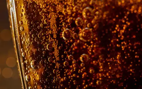 PepsiCo US7134481081 in extremer Makroaufnahme von KohlensÀureblasen in bernsteinfarbenem generischem GetrÀnk ohne Logo - Foto: THN