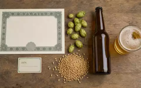 Flatlay mit Aktienzertifikat, ISIN-Karte und Hopfen zeigt die Aktie Anheuser-Busch InBev, ISIN BE0974293251 - Foto: THN