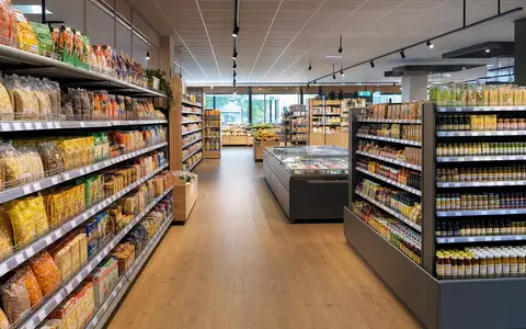 Ahold NL0011794037 fotorealistischer Blick in einen hellen europäisch niederländischen Supermarkt Innenraum mit vollbestückten Regalen - Foto: THN