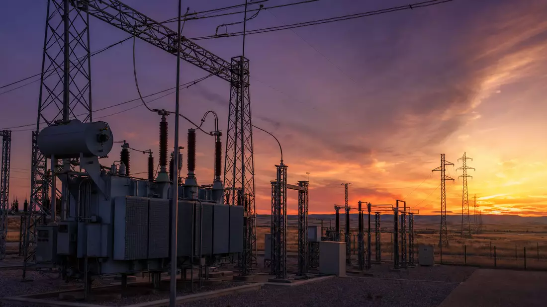 Photorealistic high-voltage substation in Spanish landscape at dusk with warm sunset sky