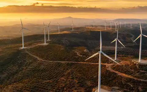 EDP Renováveis ES0144580Y14 betreibt riesige Windparks in iberischer Hügellandschaft bei goldener Abendsonne. - Foto: THN