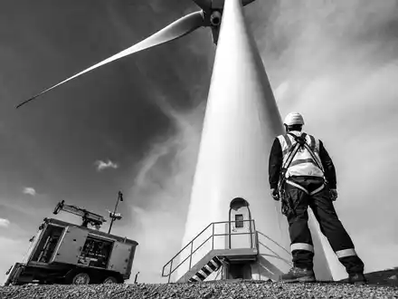 EDP Renováveis ES0144580Y14: Schwarz-Weiß-Reportage eines Technikers mit Schutzausrüstung direkt an der Turbinen-Basis - Foto: THN