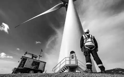 EDP Renováveis ES0144580Y14: Schwarz-Weiß-Reportage eines Technikers mit Schutzausrüstung direkt an der Turbinen-Basis - Foto: THN