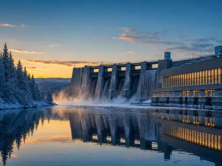 Fortum FI0009007132 nordisches Wasserkraftwerk an verschneitem See bei polarer Dämmerung mit Spiegelung - Foto: THN