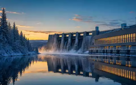 Fortum FI0009007132 nordisches Wasserkraftwerk an verschneitem See bei polarer Dämmerung mit Spiegelung - Foto: THN