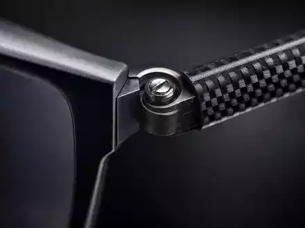 EssilorLuxottica FR0000033219 extreme macro of eyeglass hinge with precision screw on carbon-fiber temple arm - Foto: THN