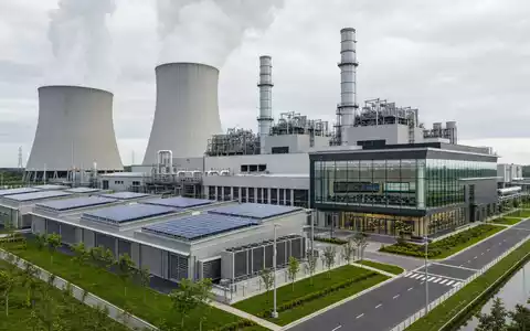 ENGIE FR0010208488 zeigt ein modernes Gaskraftwerk mit groĂen KĂŒhltĂŒrmen und Solarpanels auf DĂ€chern - Foto: THN