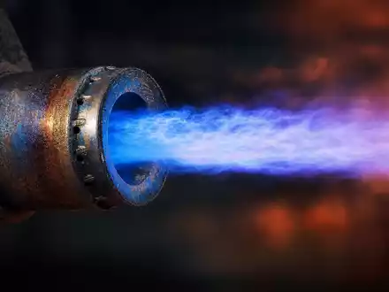 ENGIE FR0010208488 zeigt ein Makro Detail einer Gasdüse mit intensiver blauer Flamme in einem Ofen - Foto: THN
