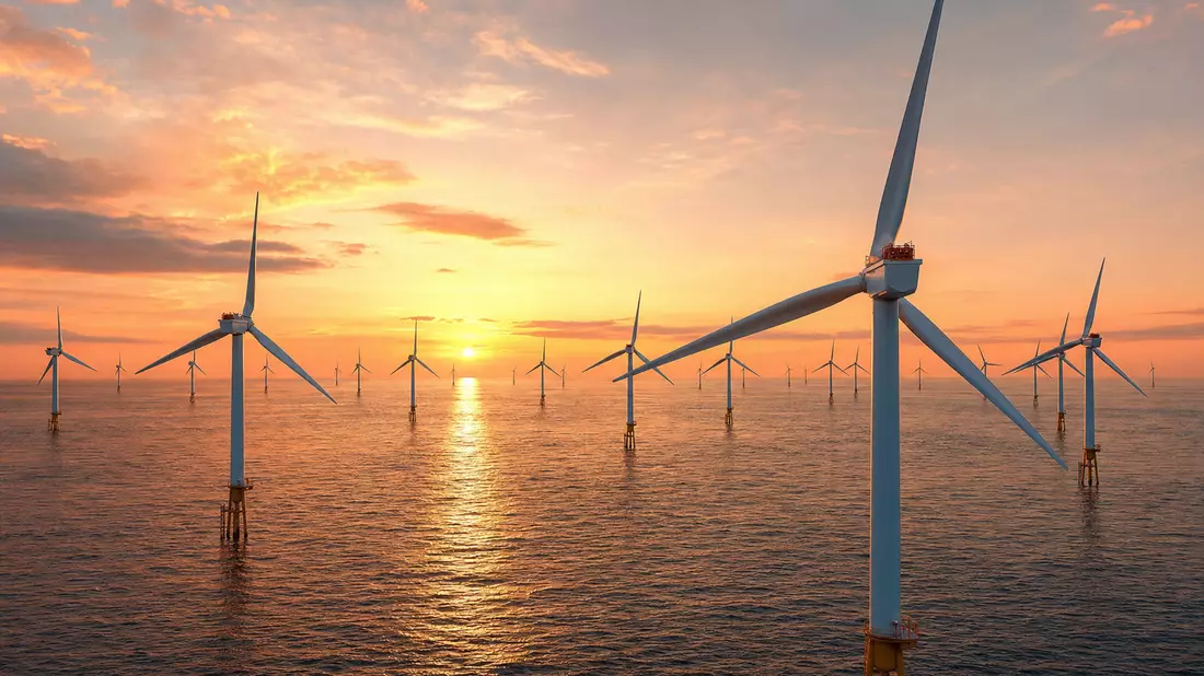 Photorealistic offshore wind farm in the North Sea at golden sunset with dozens of white turbines