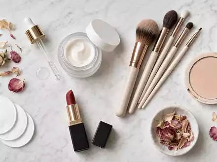 L'Oréal FR0000125486 Flatlay generischer Kosmetikprodukte mit Pipette, Pinseln und Lippenstift auf weißem Marmor - Foto: THN