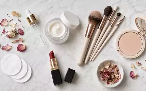 L'Oréal FR0000125486 Flatlay generischer Kosmetikprodukte mit Pipette, Pinseln und Lippenstift auf weißem Marmor - Foto: THN