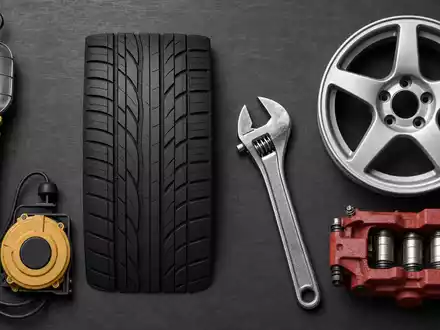 Michelin FR0000120321 Werkstatt zeigt Flatlay mit Reifenprofil-Schablone, Schraubenschlüssel, Felge, Bremssattel und Lampe - Foto: THN