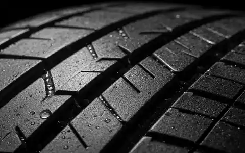 Michelin FR0000120321 Material zeigt extreme Makroaufnahme Reifenlauffläche mit nassen Rillen und Gummitextur - Foto: THN