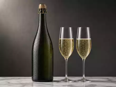 LVMH FR0000121014 zeigt eine dunkle Champagnerflasche mit Sektgläsern auf weißem Marmor fotorealistisch - Foto: THN